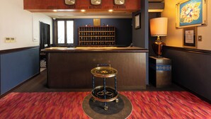 A reception area with a wooden reception desk, a clock above it, and a wall-mounted display case. - Business Hotel Hayashiso (Miyazaki)