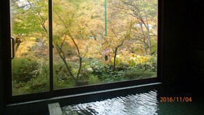 Janela com vista para um jardim com árvores e um letreiro que diz 'LOVE'.