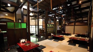 A traditional Japanese-style restaurant with tatami mat seating and wooden tables. - Guest House Kotohira (Hita)