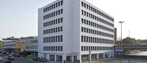 A modern building with multiple floors, large windows, and a flat roof.