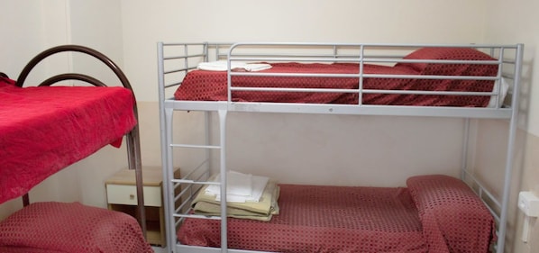 A bunk bed room with a red bedspread, a small bedside table, and a chair. - Ostello Bella Napoli (Naples)