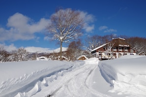 A snow-covered landscape with a building labeled "POLE POLE" and a clear blue sky. - Gassan Pole Pole Farm (Nishikawa)