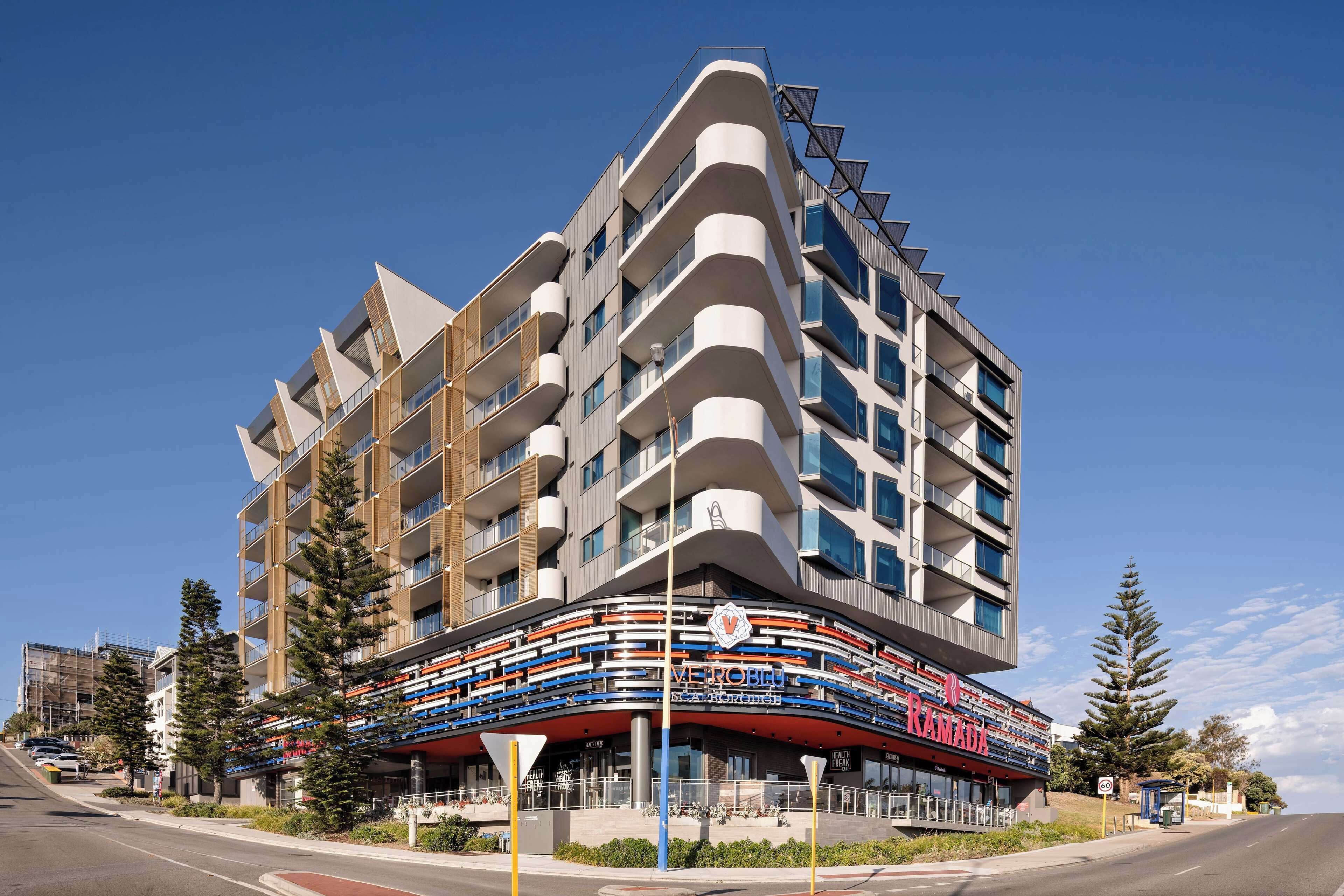 A modern multi-story building with balconies, a cinema, and a restaurant.