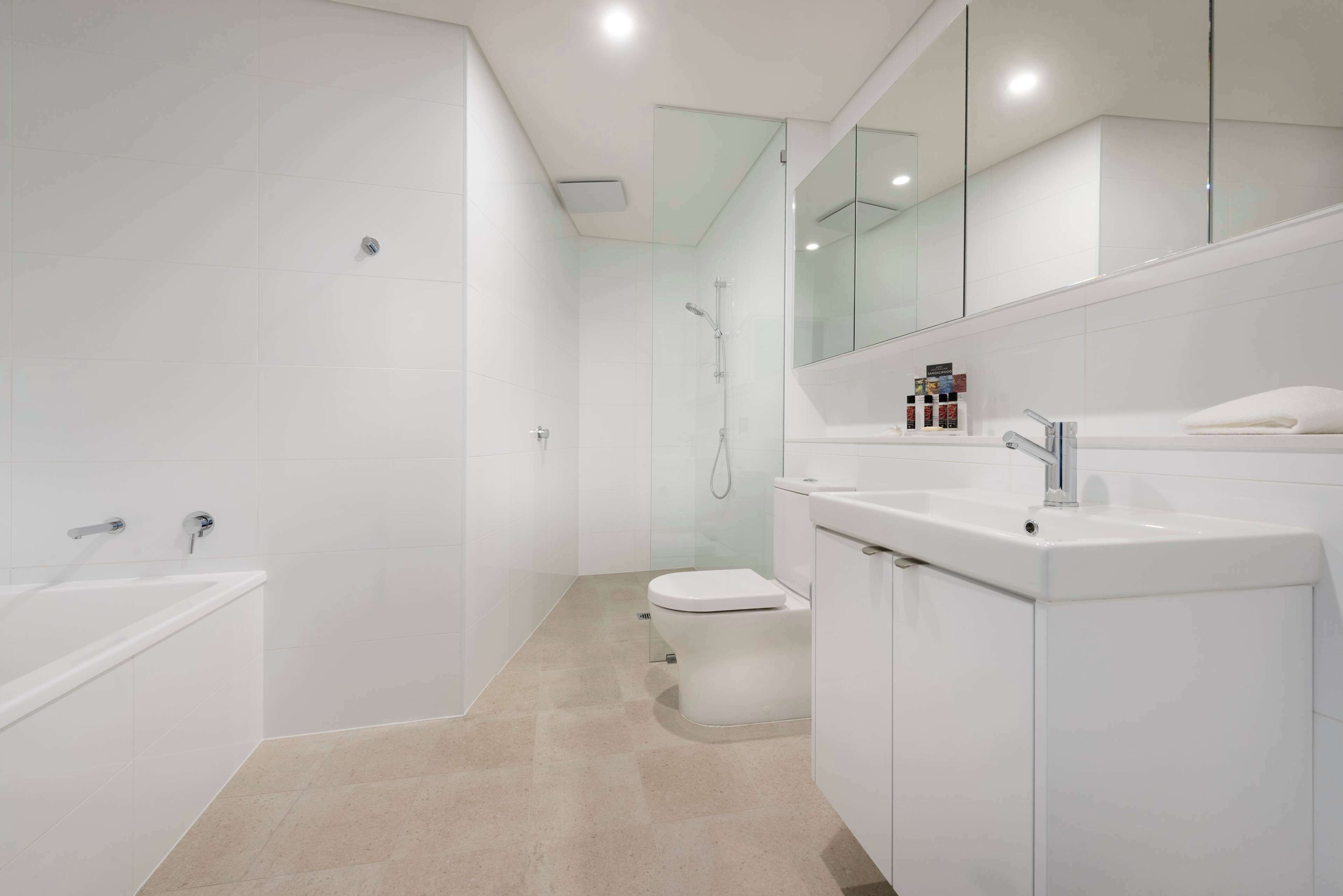 A modern bathroom with a bathtub, toilet, and sink.