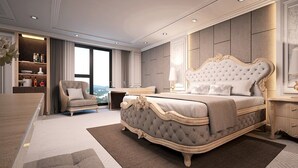 Ein luxuriöses Schlafzimmer mit einem großen Bett, einer Sitzecke inklusive Sessel, einem Schreibtisch und einem Bücherregal.