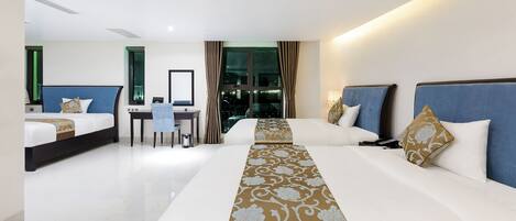 A hotel room with two beds, a desk, and a view of the city.