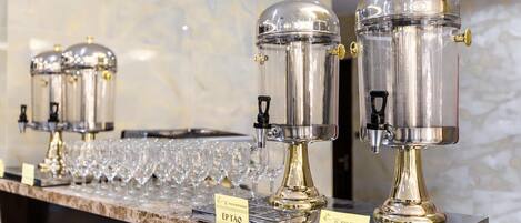 Una hilera de dispensadores de café con las etiquetas "EPTAO" y "NUOC LUC" sobre una encimera de mármol.