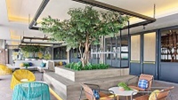 A modern outdoor seating area with a tree, a small table, and chairs. - Rooms Inc Semarang (Semarang)