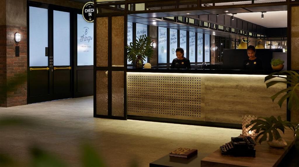 A reception area with a check-in counter, a receptionist, and a reception desk.
