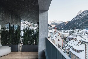 Een balkon met uitzicht op een besneeuwde stad en bergen.