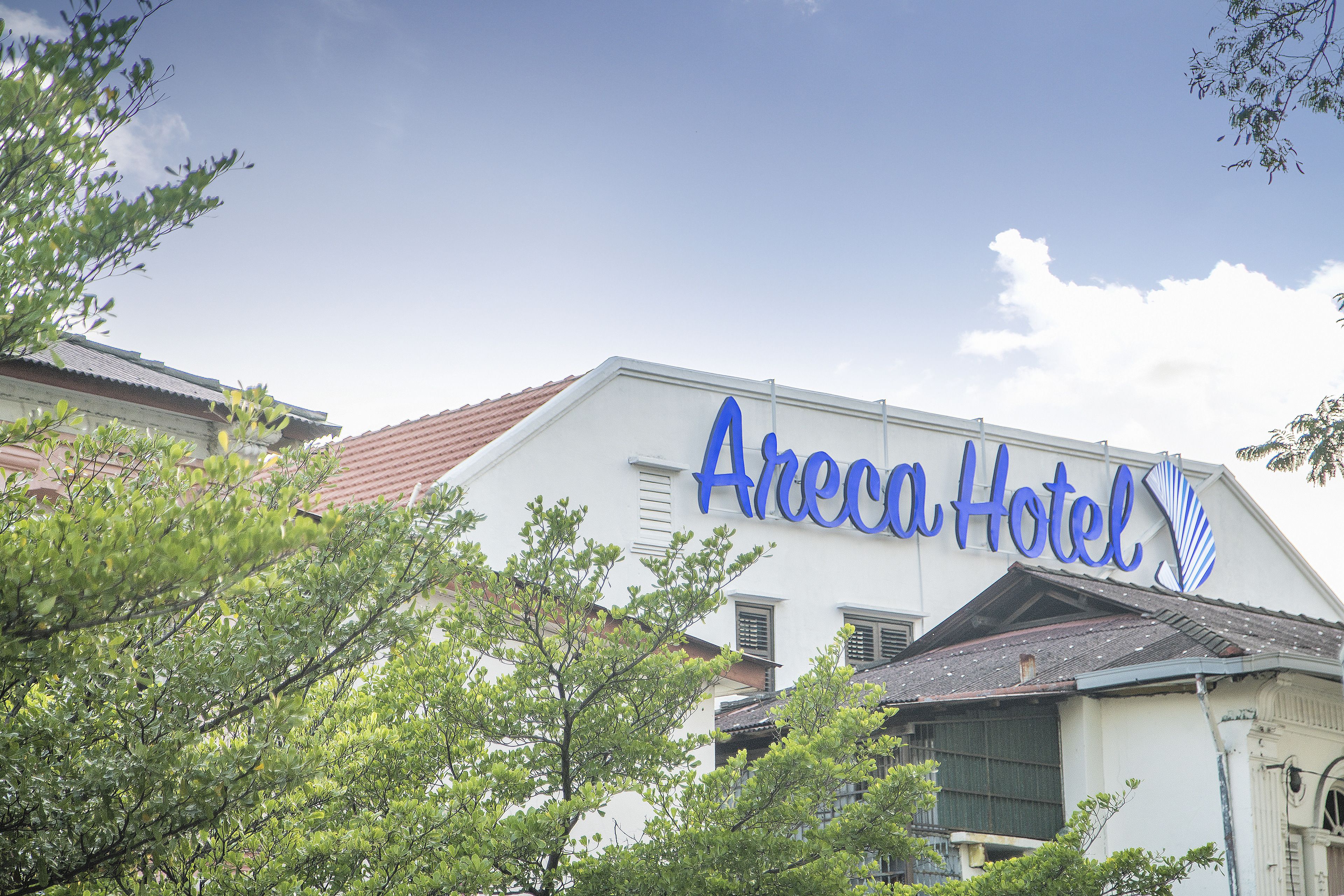 En hotellskylt med namnet ”Areca Hotel” skrivet med blå bokstäver.