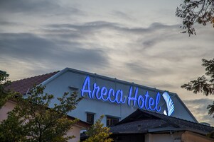 Az Areca Hotel külső homlokzatán feltűnő, világító neonfelirat látható.