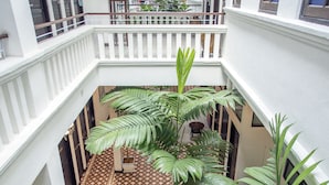 A multi-level atrium with a central courtyard featuring large green plants and patterned flooring. - Areca Hotel Penang (George Town)