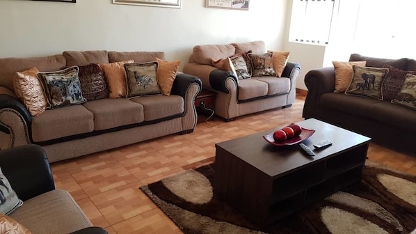 A living room with two sofas, a coffee table, and a rug.