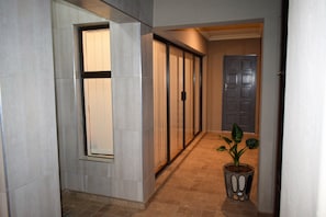 A hallway with a potted plant, a sliding door, and a door with a handle.