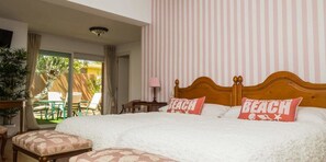 Relax in this serene hotel room with a large bed, balcony, and garden view.