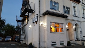 A building with a sign reading "FAIRHAVEN" and a fire escape.