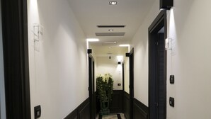 A hallway with a marble floor, black and white walls, and doors on both sides. - Chez Anna B&B (Naples)
