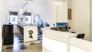A modern kitchen with a central island, bar stools, and a refrigerator. - Chez Anna B&B (Naples)