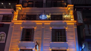 A hotel with a classic facade, illuminated signage, and a visible entrance with seating outside. - Magnaura House Hotel (Istanbul)