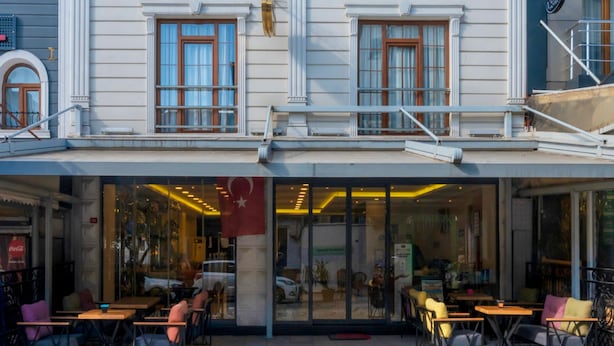 A multi-story building with a ground-floor café featuring outdoor seating. - Magnaura House Hotel (Istanbul)