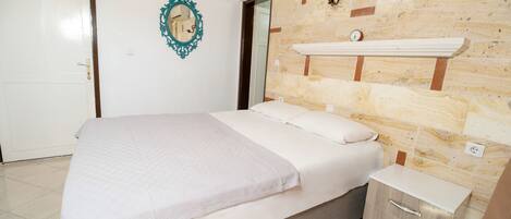 Un dormitorio con cama, cómoda, espejo y un reloj en la pared.