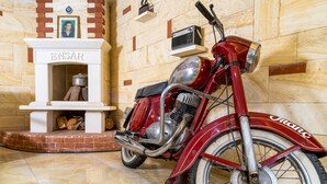 A vintage motorcycle in a room with a fireplace, wooden walls, and a tiled floor. - Foca Ensar Hotel (Foça)