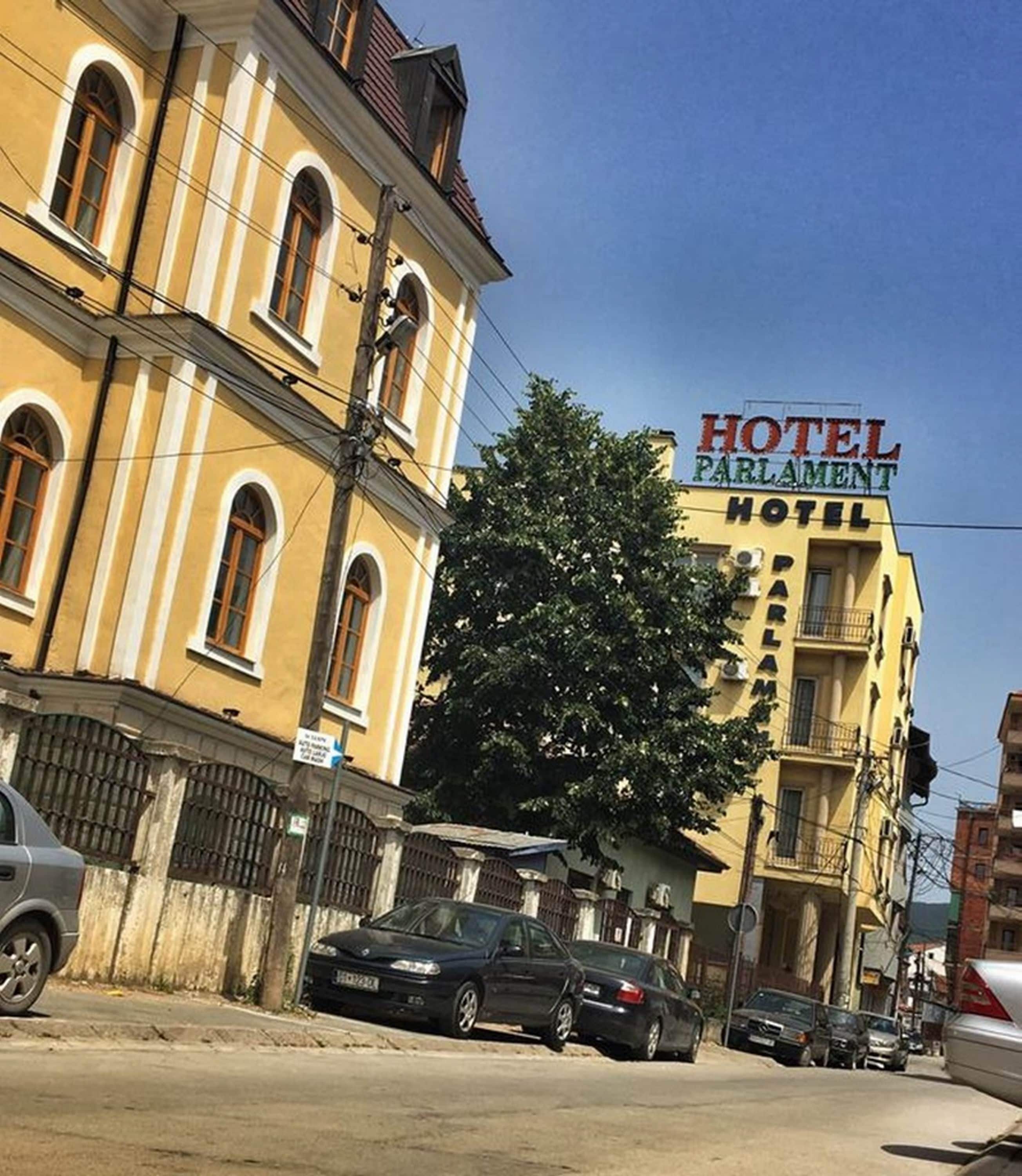 En gul byggnad med en skylt som visar texten ”HOTEL PARLAMENT HOTEL”.