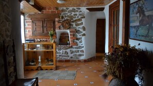 A rustic interior with a stone wall, wooden cabinets, and a fireplace. - El Refugio de Gredos - Hostel (Navarredonda de Gredos)