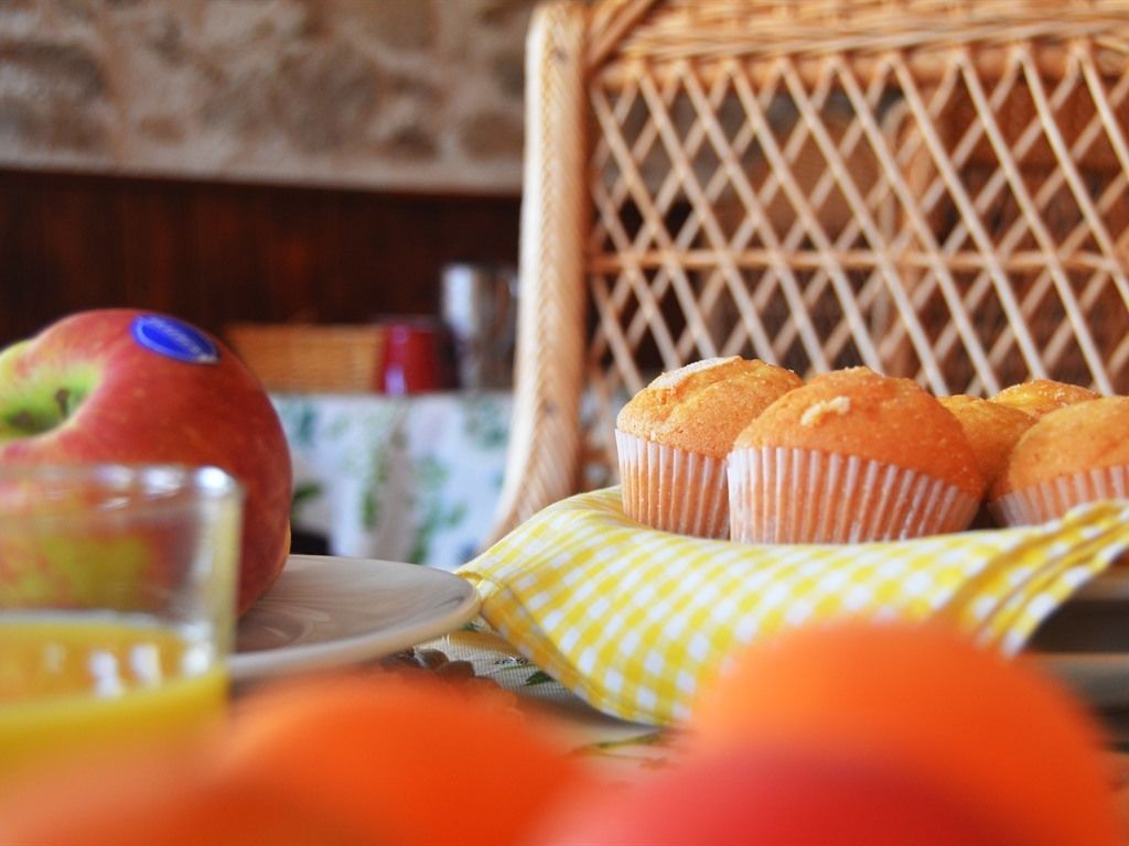 A wicker chair with a plate of muffins and a glass of orange juice.