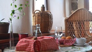 A table set with a checkered cloth, a basket, a cup, and a glass. - El Refugio de Gredos - Hostel (Navarredonda de Gredos)