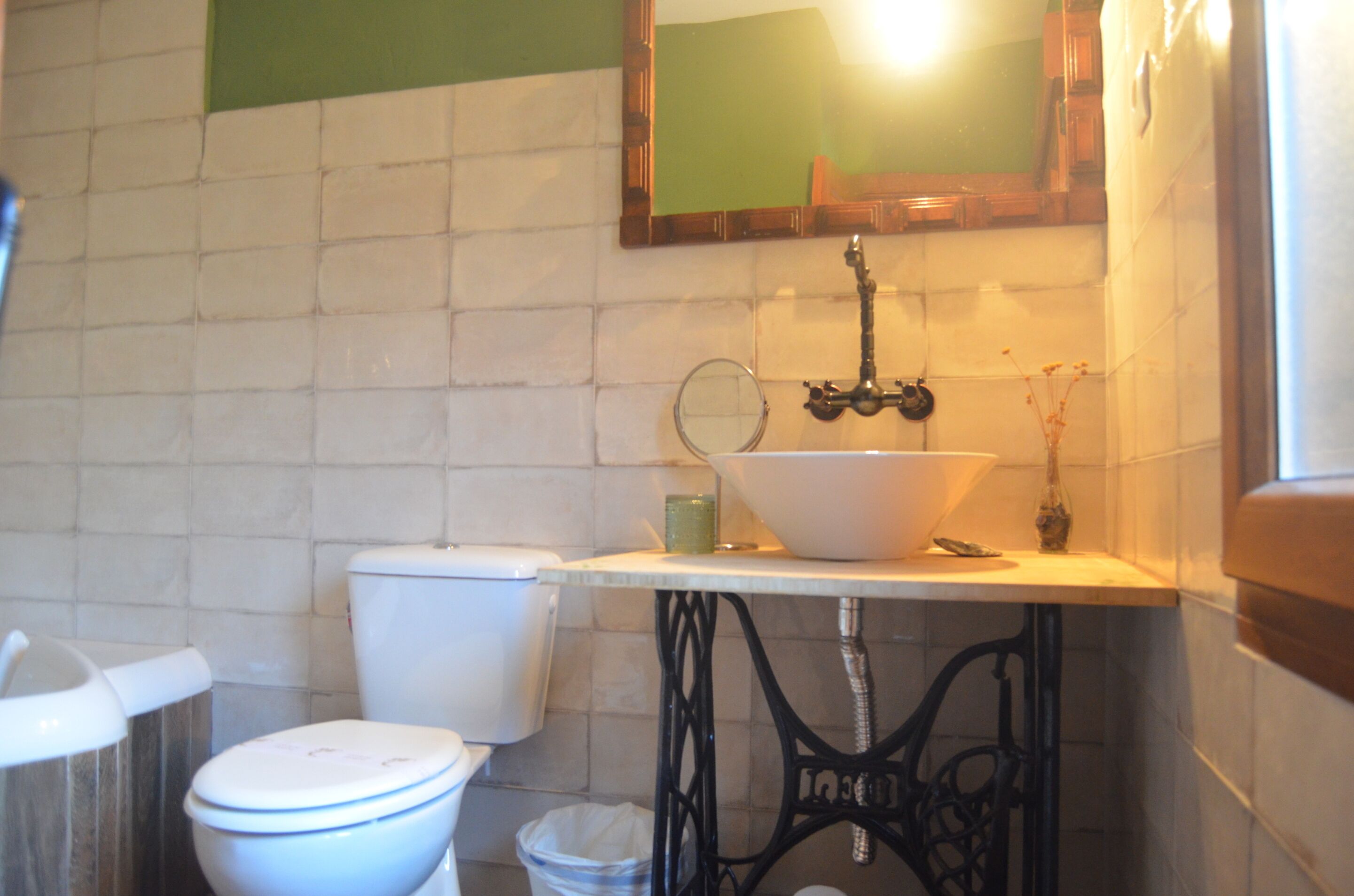 A bathroom with a toilet, sink, and mirror.