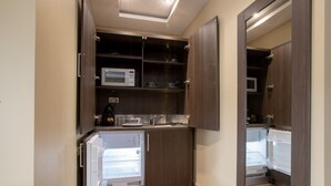 A compact kitchen with a built-in microwave, a sink, and a refrigerator. - Grainger Apartments (Newcastle-upon-Tyne)