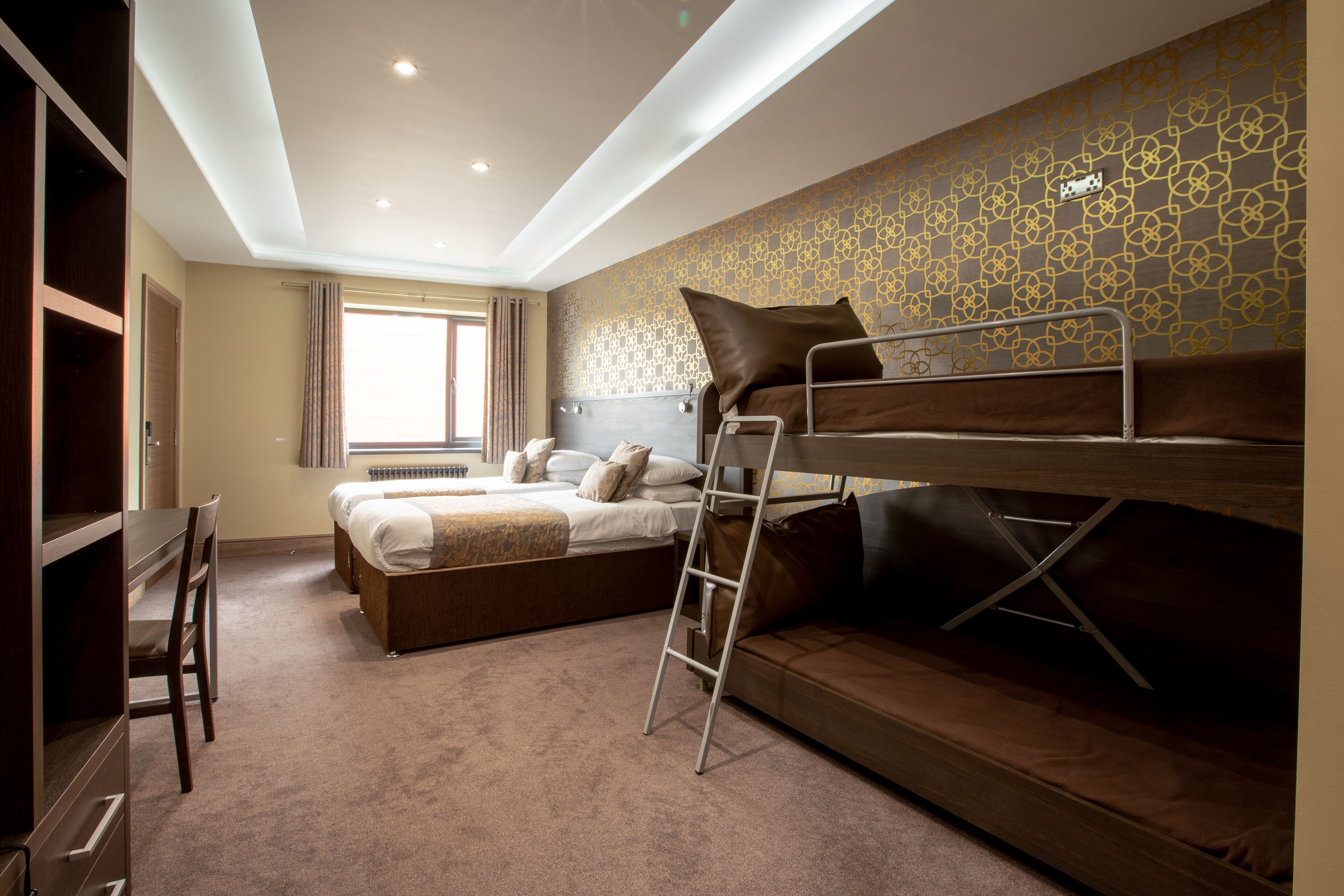 Un dormitorio con una cama litera, un escritorio y una silla.