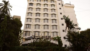 Un hotel de varios pisos con una fachada simétrica, numerosas ventanas y un letrero que indica que es un hotel.