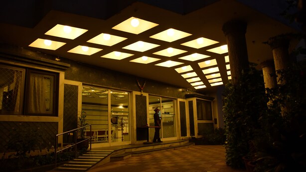 Un edificio de diseño moderno, con una amplia entrada de vidrio y una estructura de techo geométrica.