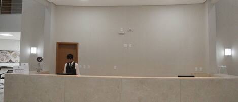 A reception area with a marble counter, a wooden door, and a globe on a stand.