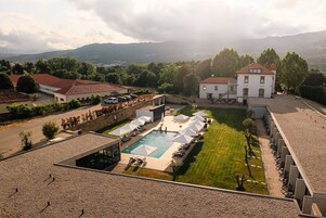 Una piscina cubierta, una piscina al aire libre, tumbonas