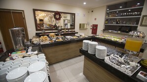 A buffet area with various food items, plates, and utensils.