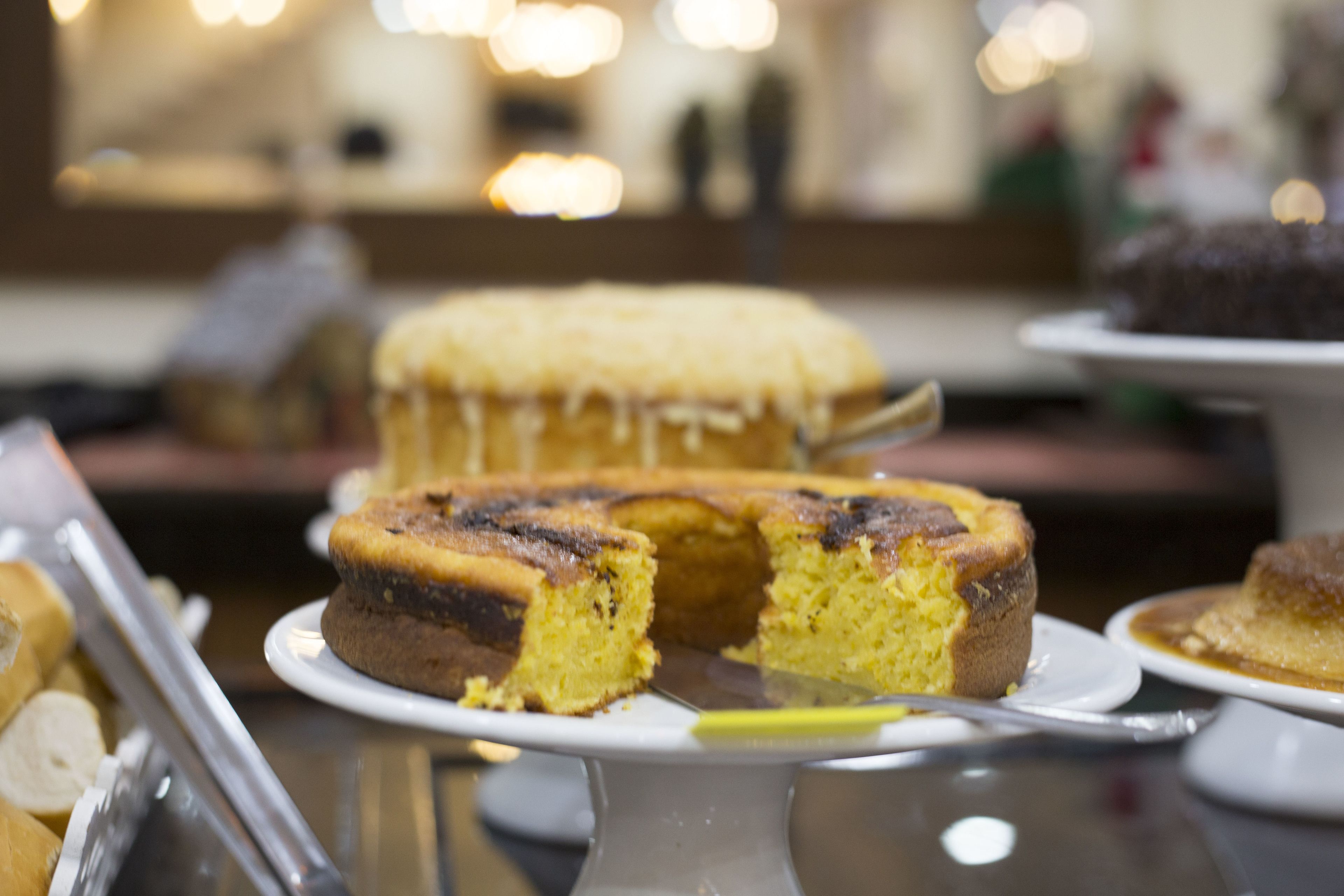Un gâteau, posé sur une assiette blanche, dont une part a été coupée.