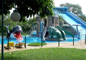 A water park with slides, a pool, and a building in the background. - Resort Hotel Atlantic City Náutico Clube (Teresina)
