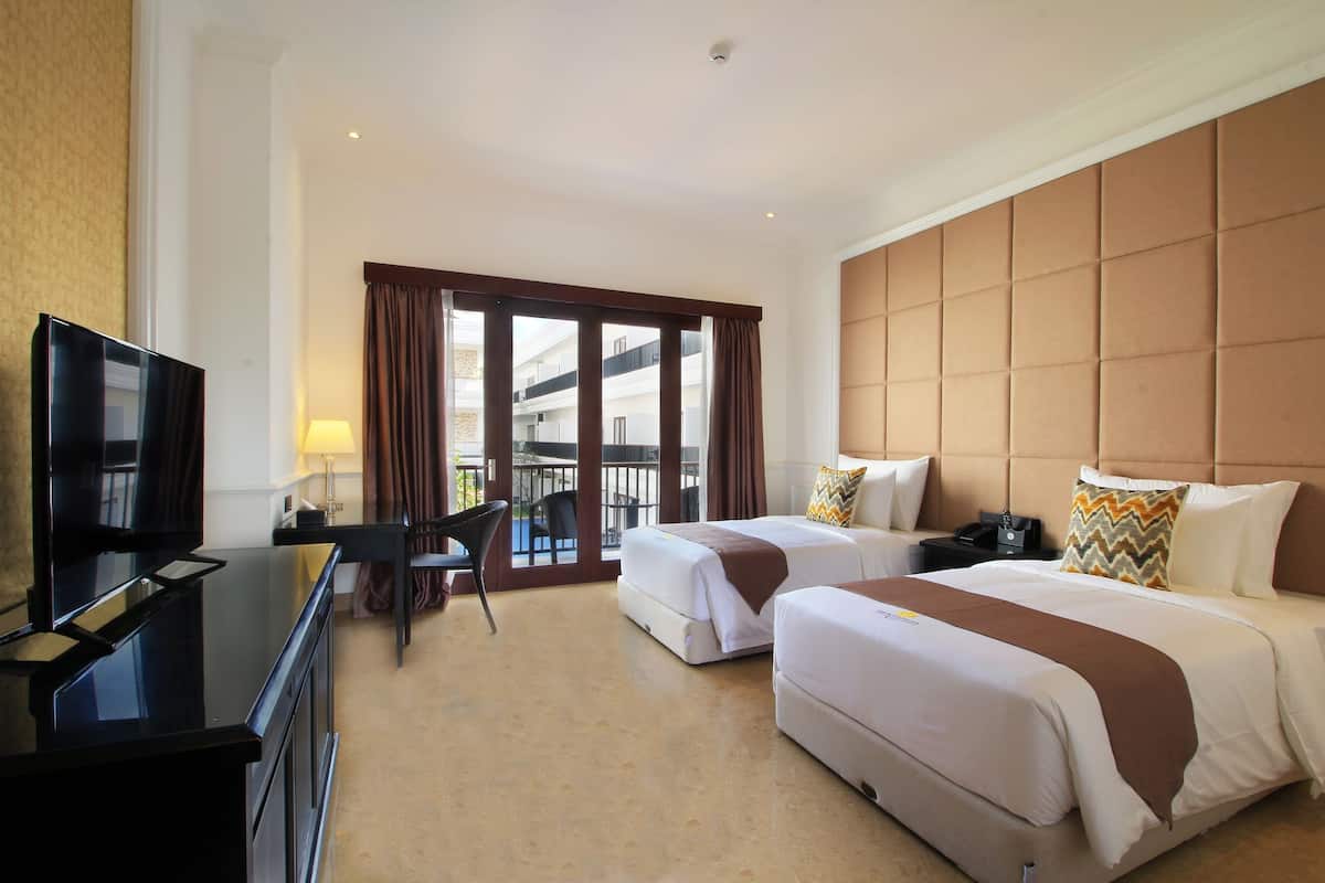 Une chambre d’hôtel avec deux lits, une télévision, un bureau et une chaise.