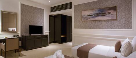 Een hotelkamer met twee bedden, een bureau, een televisie en een schilderij aan de muur.