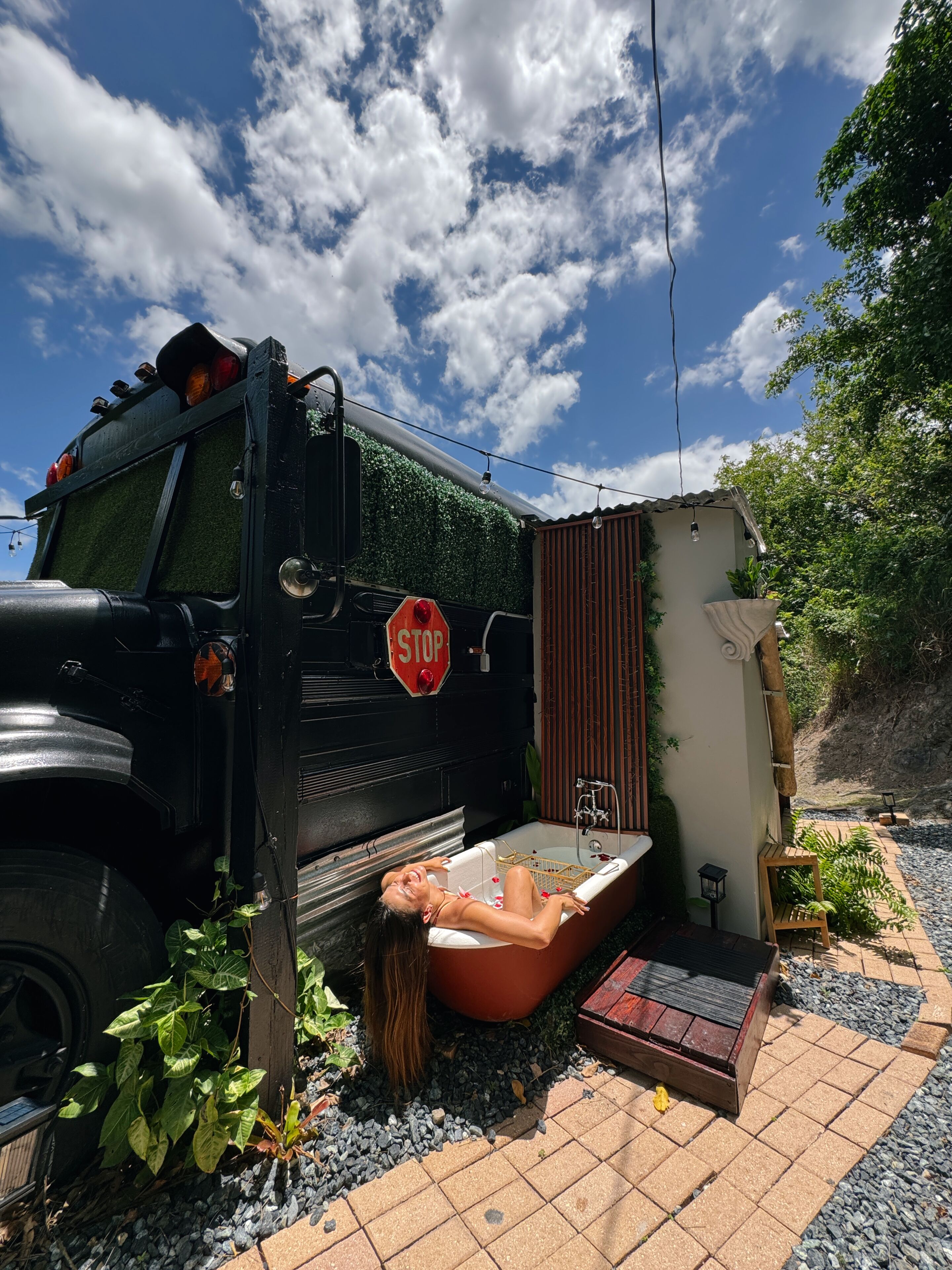 A black truck with a stop sign, a bathtub, and a small garden area.