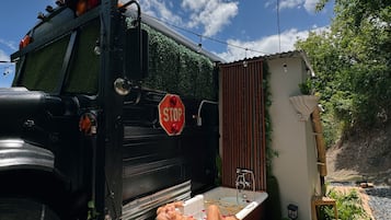 A black truck with a stop sign, a bathtub, and a small garden area.
