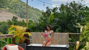 A person sitting on a hot tub with a tropical garden view. - Hacienda Tres Casitas (Cabo Rojo)