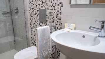 Un baño con inodoro, lavamanos y ducha.