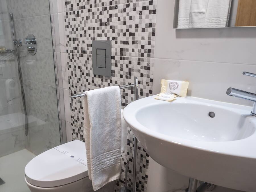 Un baño con inodoro, lavamanos y ducha.