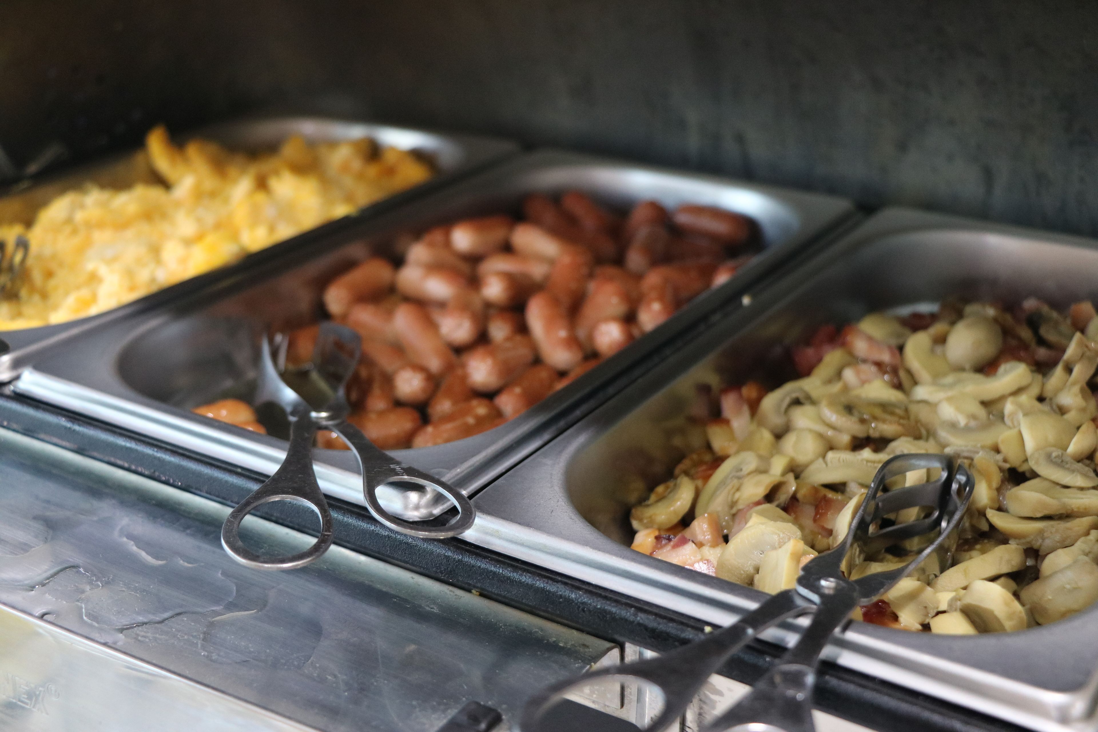Ein Buffet mit verschiedenen Speisen, darunter Bohnen, Eier und Gemüse.