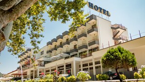 Un hotel con varios balcones, cielo despejado y un cartel que dice 'HOTEL'.